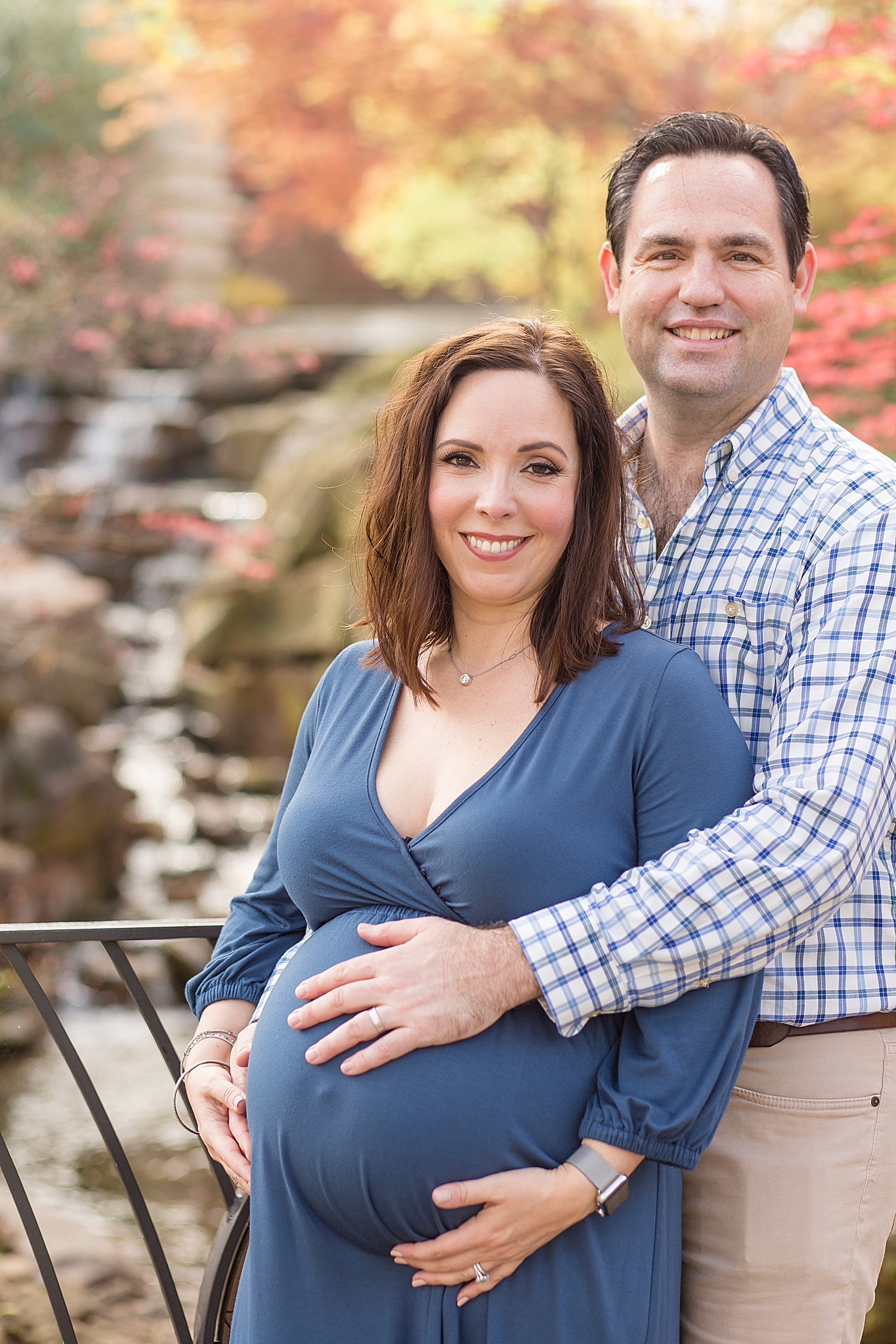 Dallas Arboretum maternity portraits for couple posing by waterfall
