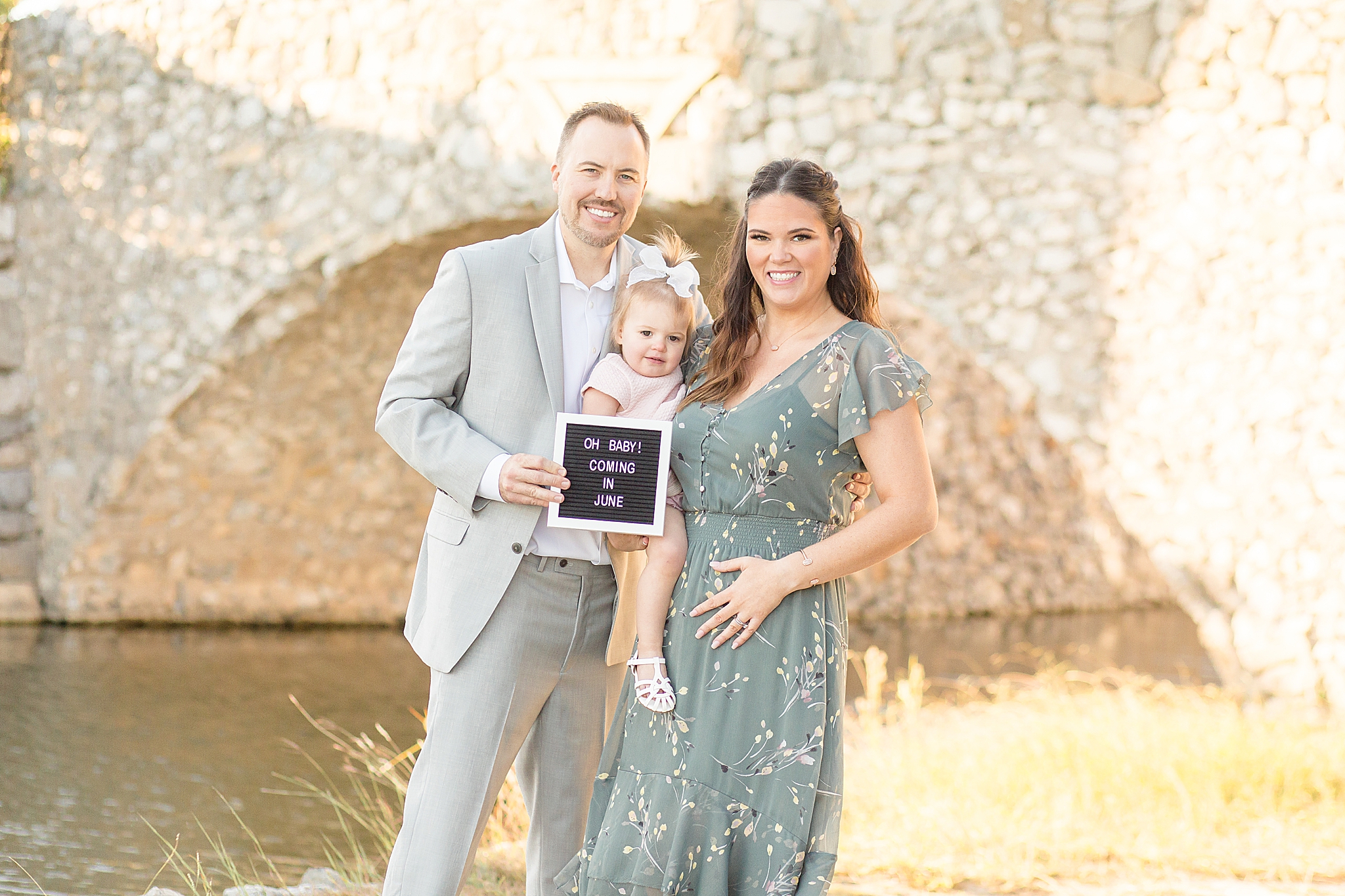family of three shares pregnancy announcement during Spring Adriatica Village family portraits