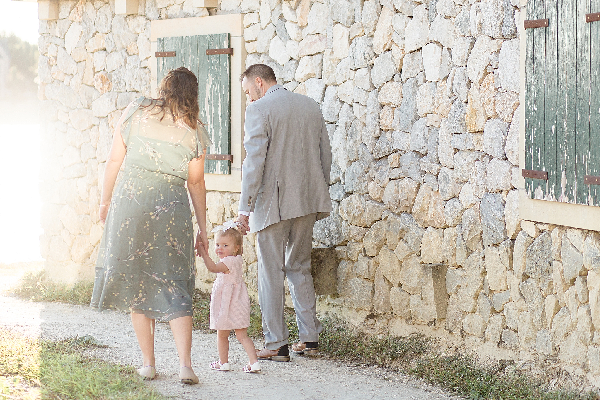 parents help toddler daughter walk through Adriatica Village