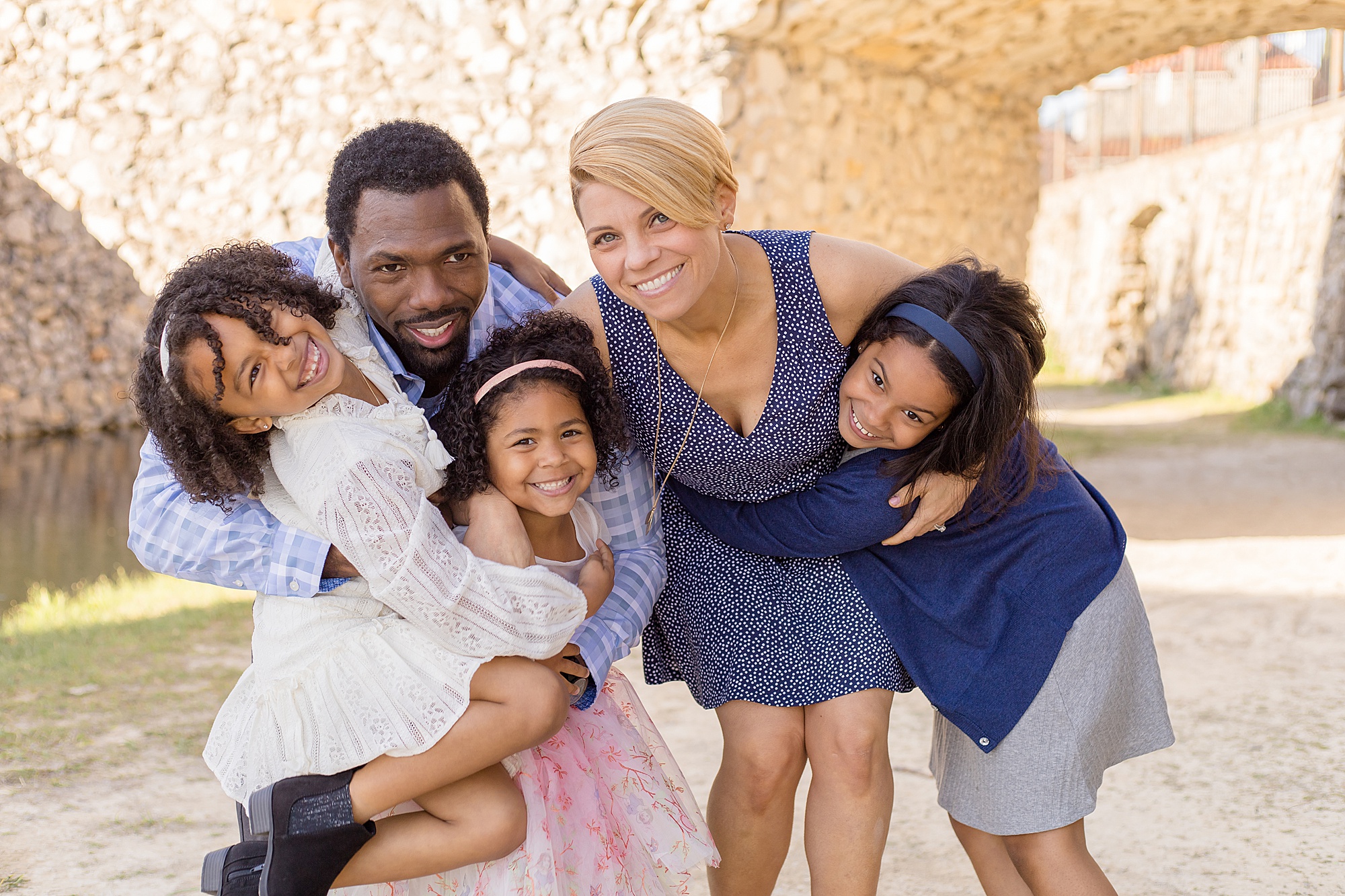 family of 5 poses at adriatica village in mckinney tx for spring family portrait session