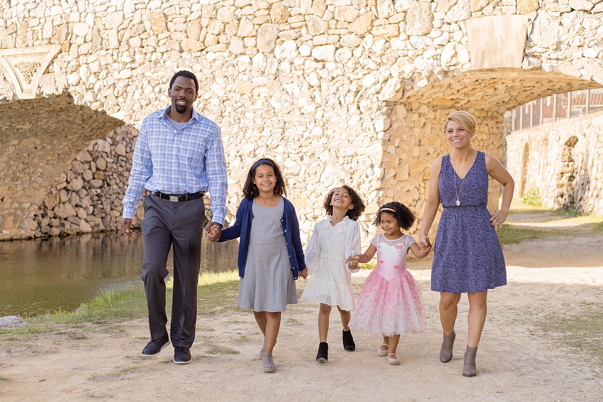family of 5 walks under bridge during family session with Wisp + Willow Photography Co. 