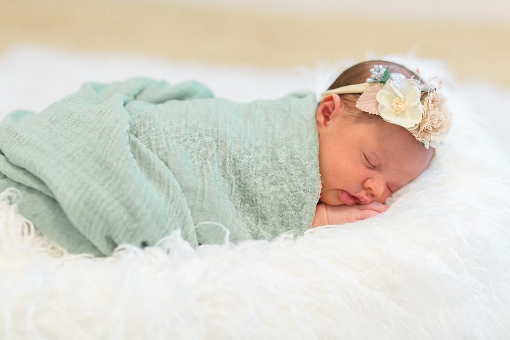 newborn baby girl sleeps on tummy during lifestyle newborn session in client's home 