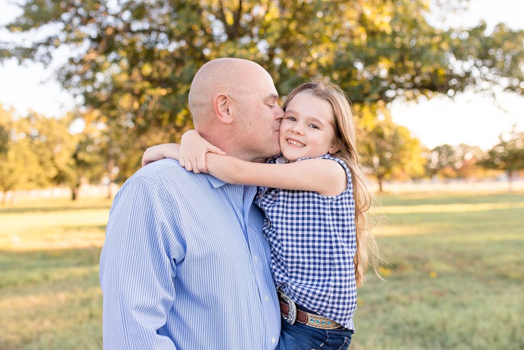 Dad kisses daughter during family session on family farm in McKinney, TX with Wisp + Willow Photography Co. 