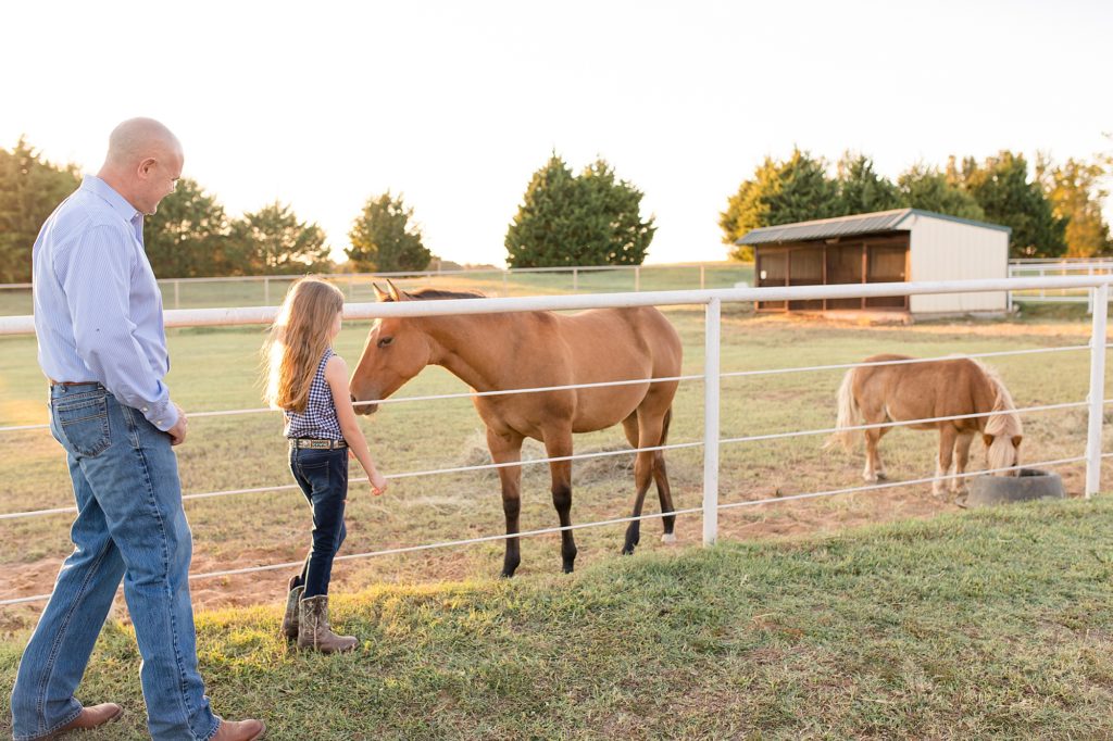 Girl plays with horses on family farm for texas family photos