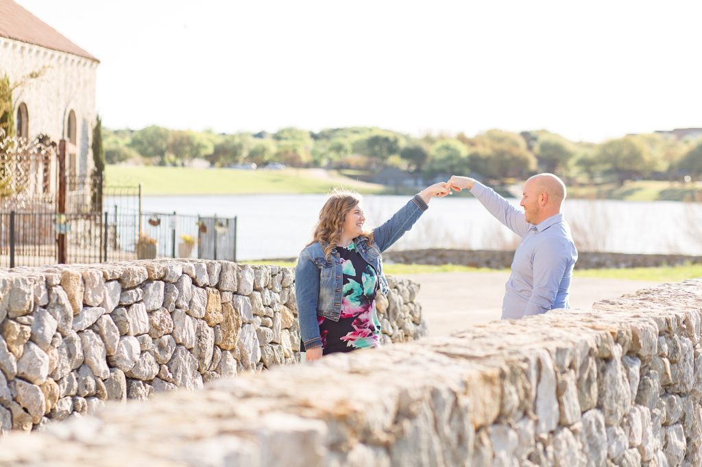 Husband twirls wife around at Adriatica Village in McKinney Texas for couple session with Wisp + Willow Photography Co.