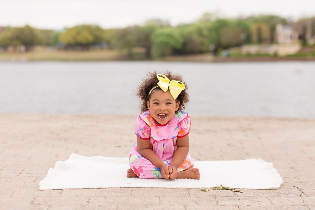 girl smiles by reservoir for mommy and me session with Wisp + Willow Photography Co.