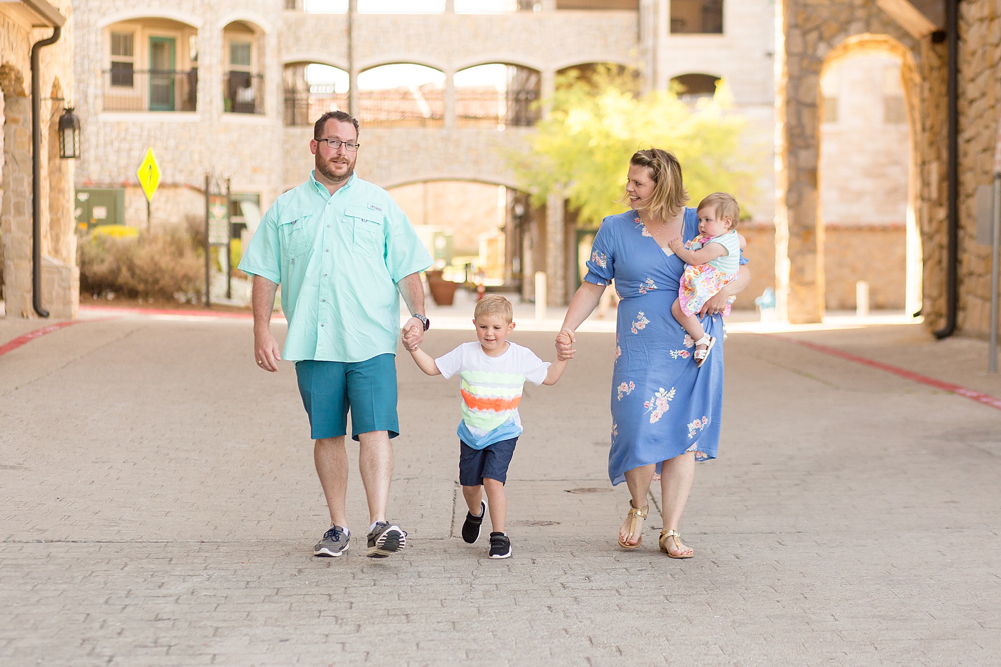 family walks under awning at Adriatica Village for family photo session with Wisp + Willow Photography Co.