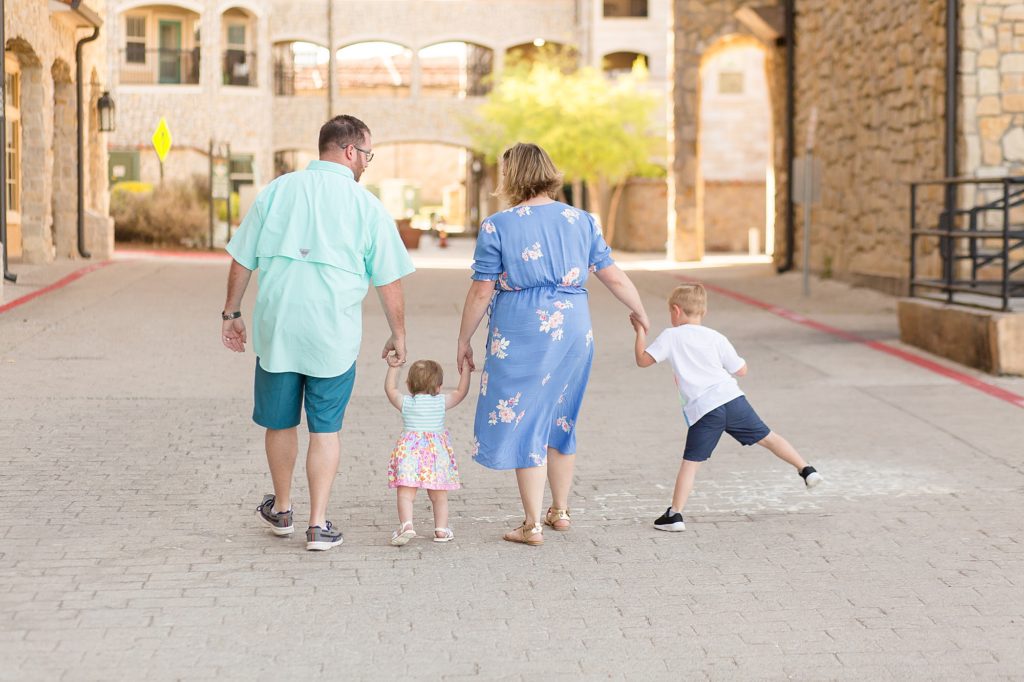 family walks through Adriatica Village for spring family session with Wisp + Willow Photography Co.