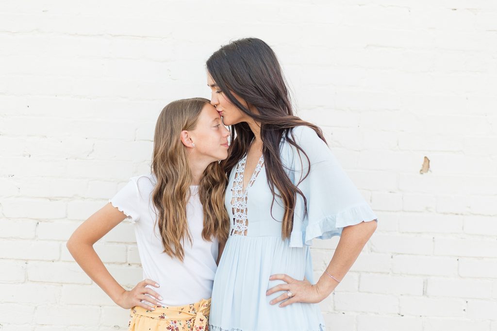 mom kisses daughter on forehead for family portrait session with wisp + willow photography co. 