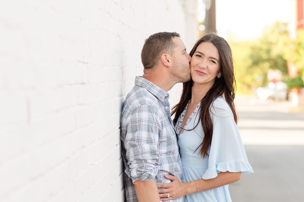 couple poses in alley in downtown mckinney square for family portrait session with wisp + willow photography co. 