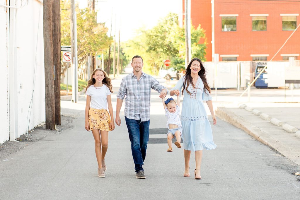 family walks in alley for portrait session with wisp + willow photography co. 