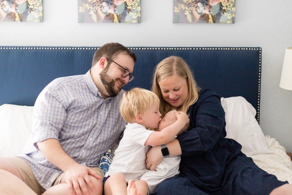 Family of 4 poses during lifestyle newborn session with nashville family photographer Wisp + Willow Photography Co.  