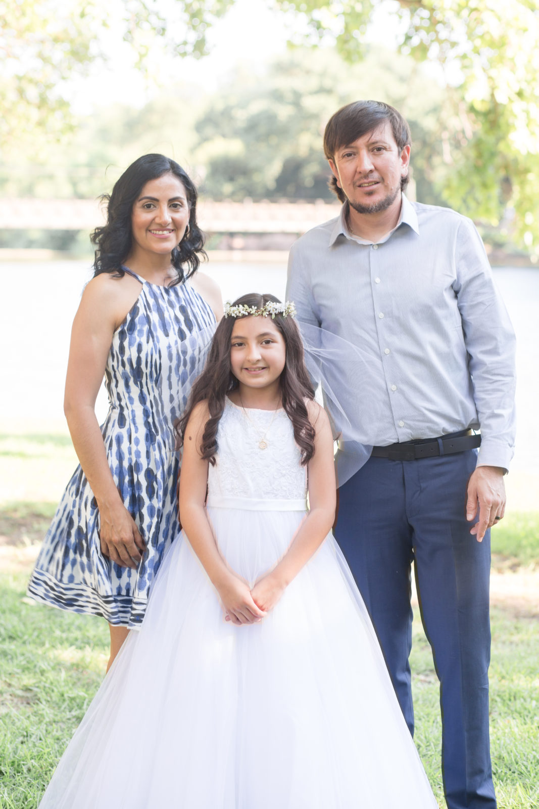 Mom and dad pose with daughter for first communion photos with event photographer Wisp + Willow Photography Co