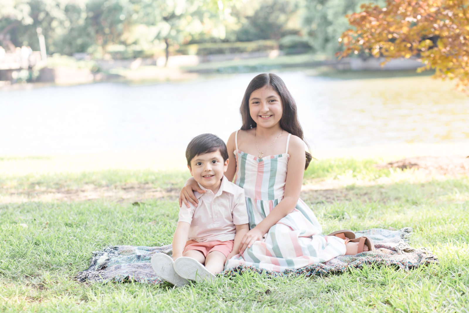 Brother and sister sit on blanket in front of pond during family portrait session with Dallas family photographer Wisp + Willow Photography Co. 