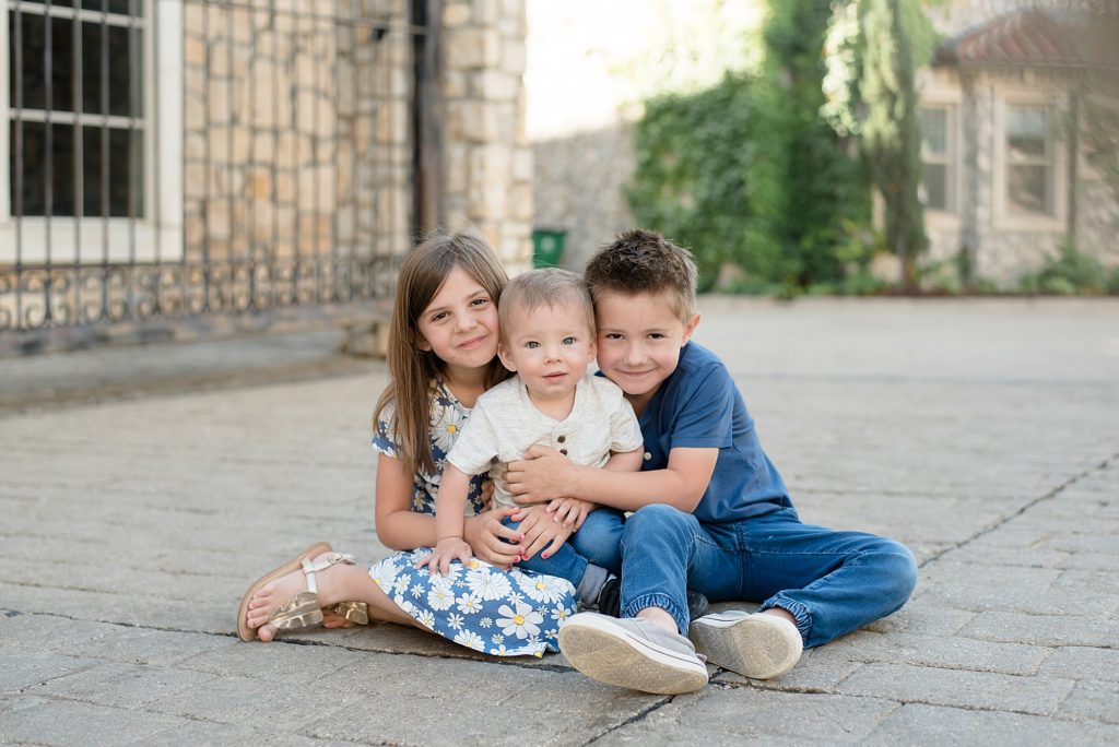 kids pose on walkway during family session with Adriatica Village photographer Wisp + Willow Photography Co. 