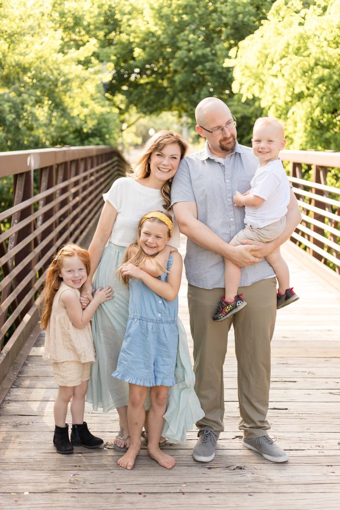 Family of 5 poses on bridge at Pinkerton Park in Franklin, TN with family photographer Wisp + Willow Photography Co.