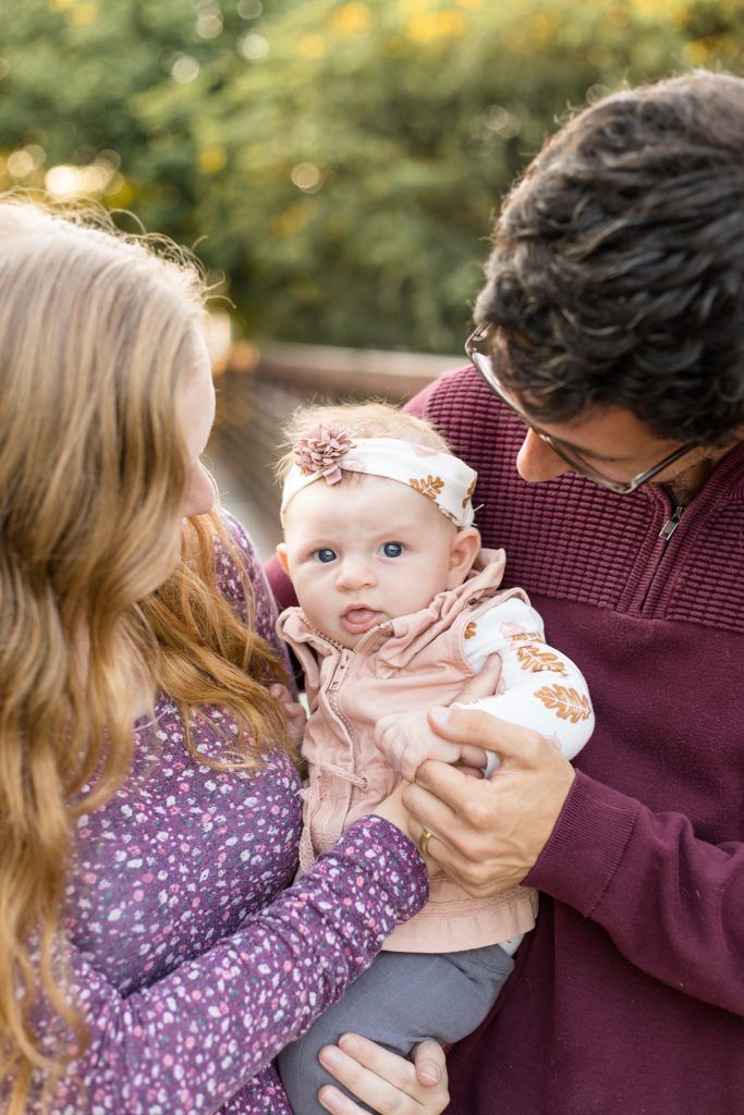 parents hold baby girl during pinkerton park mini session with Wisp + Willow Photography Co.