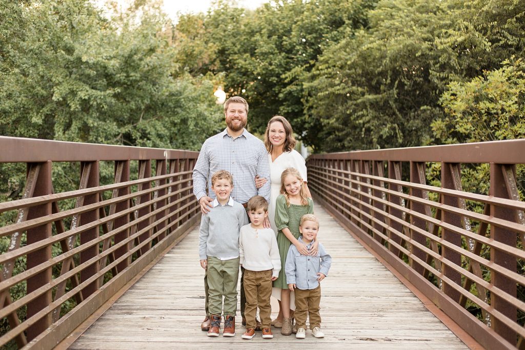 family poses on bridge during fall mini session at Pinkerton Park with Wisp + Willow Photography Co.
