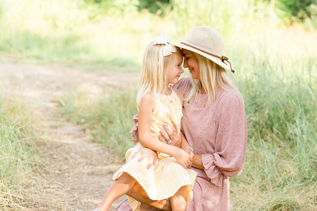 Plano family photographer captures mom and daughter during family portrait session in the summer at Arbor Hills Nature Preserve in Plano, TX. 