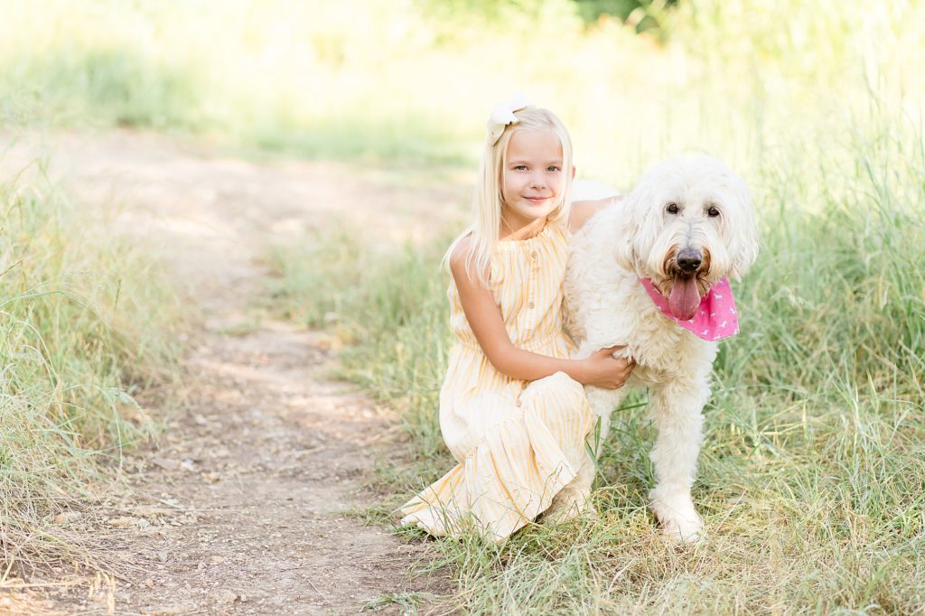 Little girl hugs dog during family portraits at Arbor Hills Nature Preserve in Plano, TX with Wisp + Willow Photography Co. 