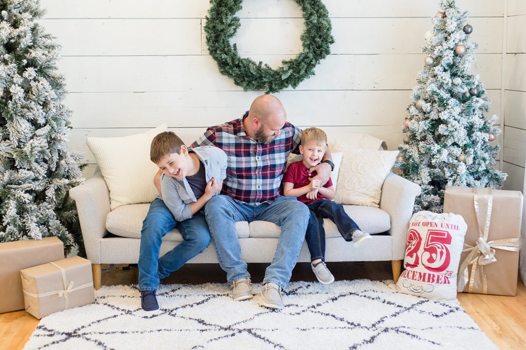 Dad plays with sons during Christmas session with McKinney mini sessions photographer Wisp + Willow Photography Co. 