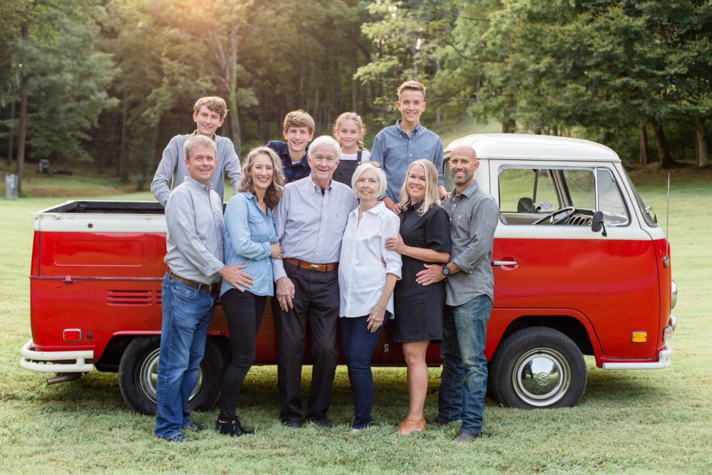 family poses in front of antique red truck with nashville family photographer Wisp + Willow Photography co. 