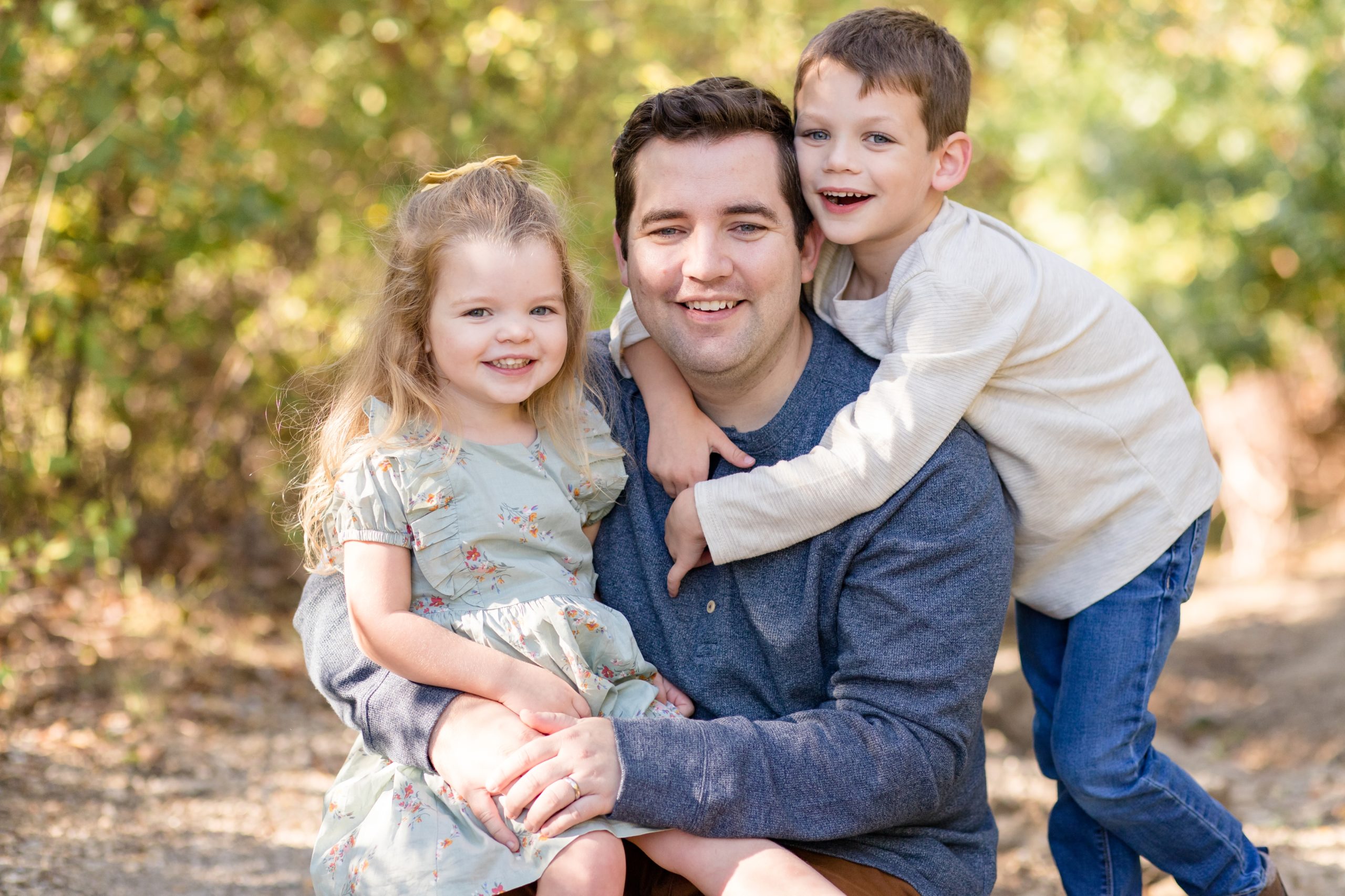 Dad poses with 2 kids during family session in the fall with Wisp + Willow Photography Co. 
