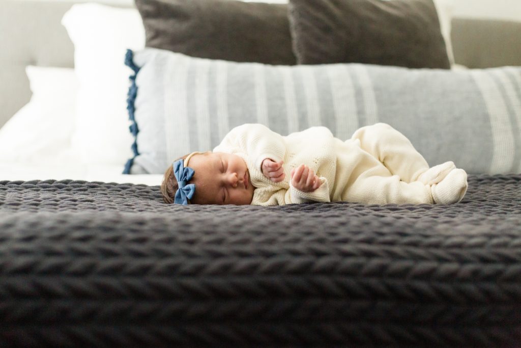 Baby sleeps on parent's bed during lifestyle newborn session with Dallas TX photographer Wisp + Willow Photography Co. 