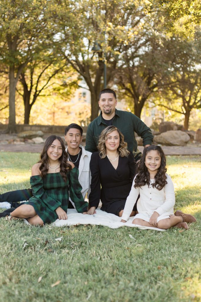 Family of 5 poses on blanket at Frisco Central Park during fall mini session with family photography team Wisp + Willow Photography Co. 