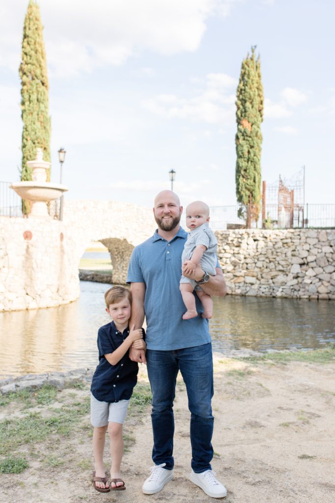 Boys pose with dad in front of Bella Donna Chapel at Adriatica Village in McKinney, TX. Click to see more from this sweet session live on the blog now!