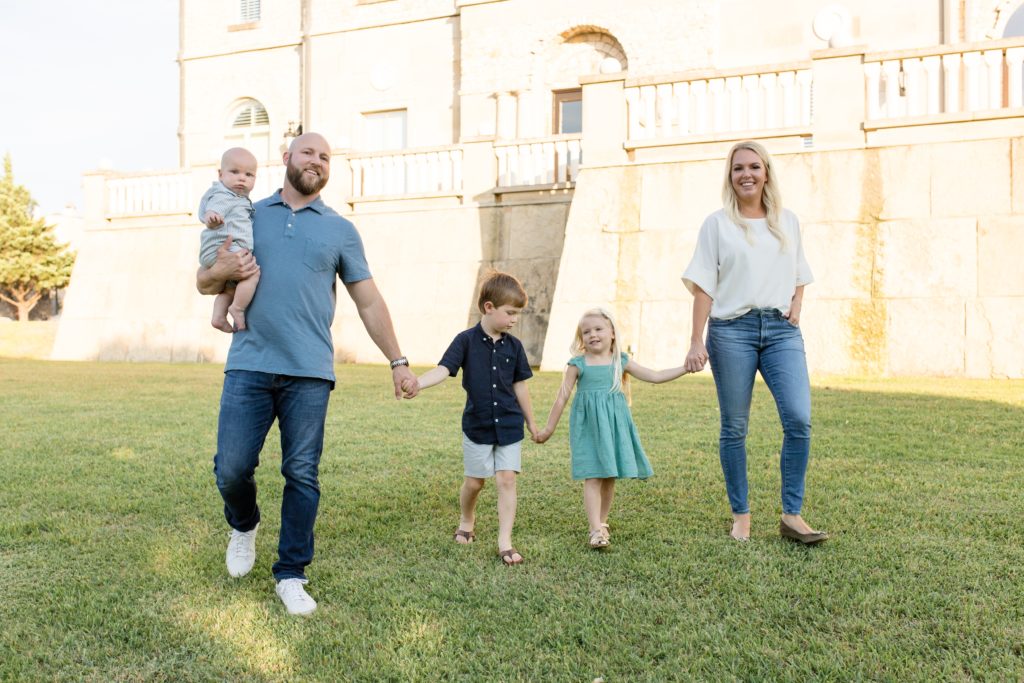 Family of 5 walks towards the camera reservoir at Adriatica Village in McKinney, TX during portrait session with family photographer Wisp + Willow Photography Co. Click to see more from this sweet session live on the blog now!
