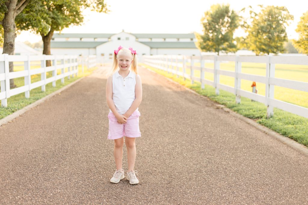 Girl in white shirt and pink bows poses during mommy and me session with family photography team Wisp + Willow Photography Co. Click to see more from this sweet session on our blog now!