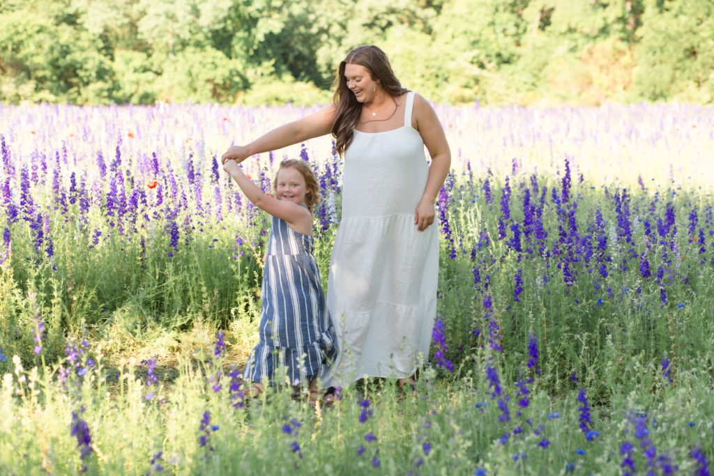 Mom and daughter dance in wildflower field during mommy and me session with Dallas photographer Wisp + Willow Photography Co.