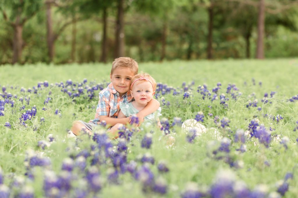 Siblings sit in bluebonnets during bluebonnet minis with Plano family photographer Wisp + Willow Photography Co. 