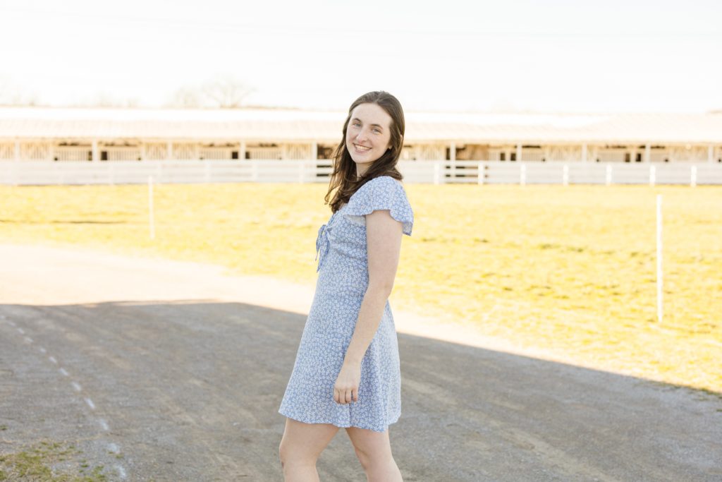 Teenage girl walks on gravel path at Harlinsdale Farm with Wisp + Willow Photgoraphy Co during senior portrait session