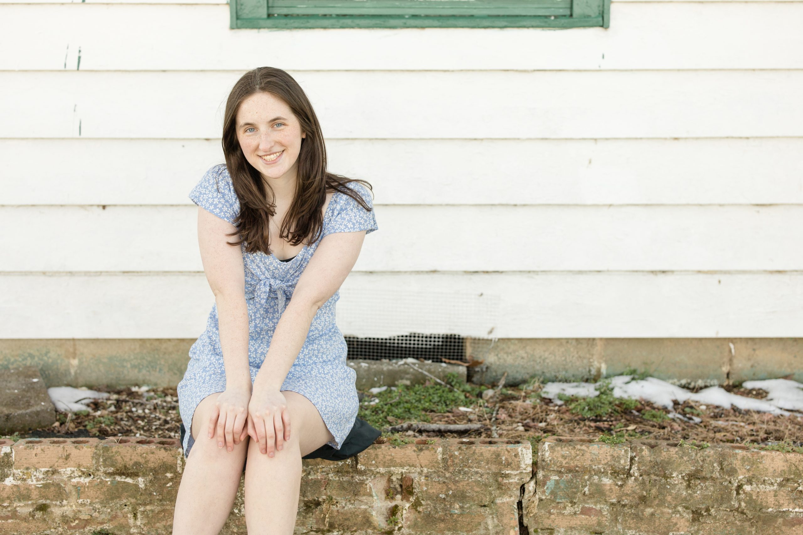 Senior in blue dress sits on steps at Harlinsdale Farm during senior portrait session in Franklin, TN with Wisp + Willow Photography Co. Click to see more from this stunning session on the blog now!