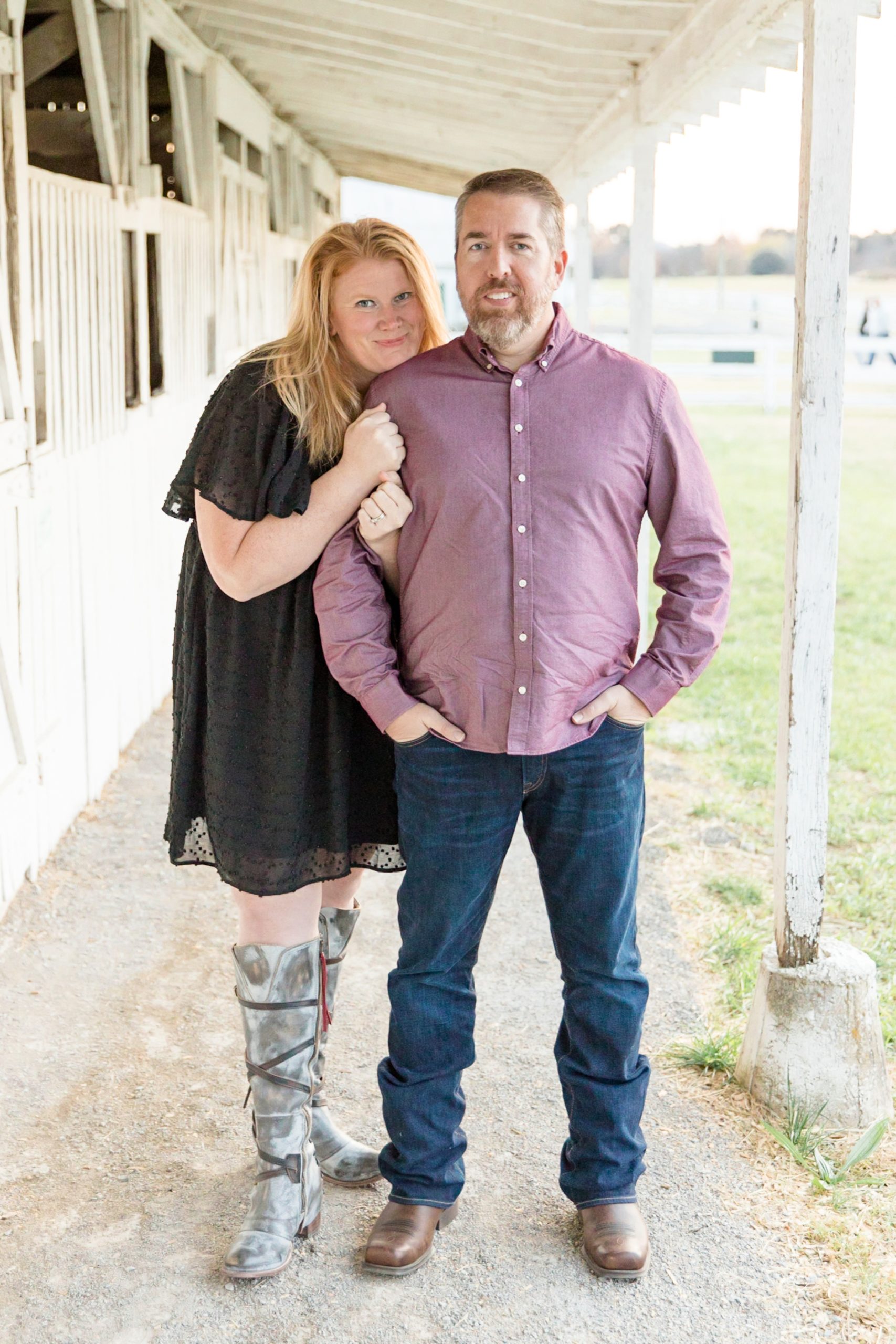Couple poses arm in arm under awning at horse stables at Harlinsdale Farm during fall family session with Wisp + Willow Photography Co. Click to read more about why we love this farm live on the blog now! 