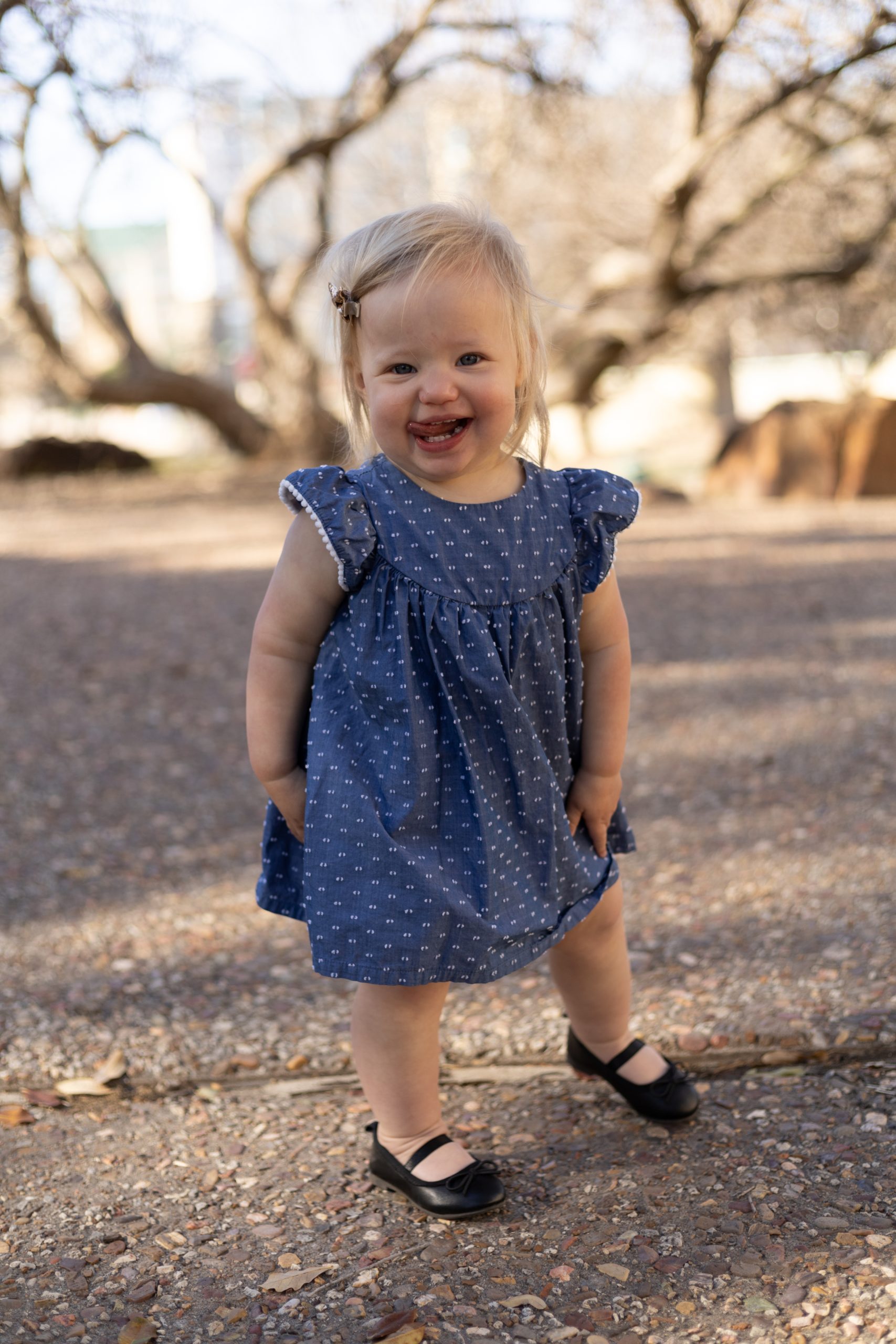 Little girl in blue dress poses during maternity session with family photography team Wisp + Willow Photography Co at Frisco Central Park. Click to see more from this session live on the blog now. 