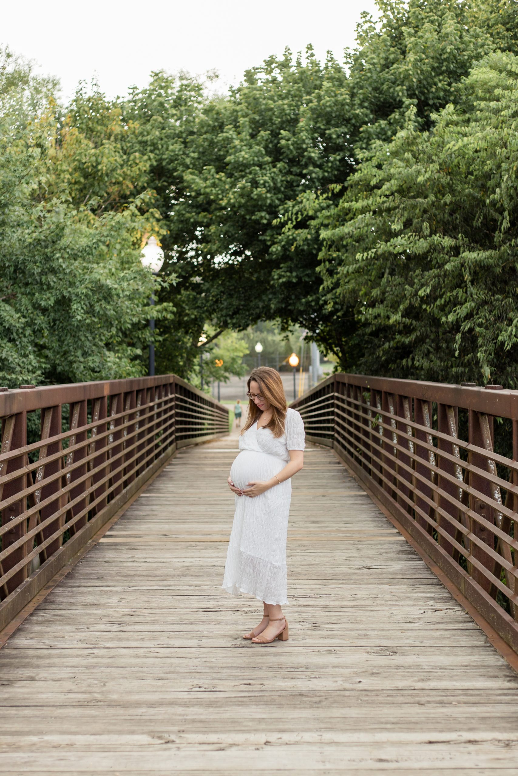 Mom holds pregnant belly at Pinkerton Park in Franklin, TN during maternity session with family photography team Wisp + Willow Photography Co. Click to read more tips on preparing for your maternity session now! 