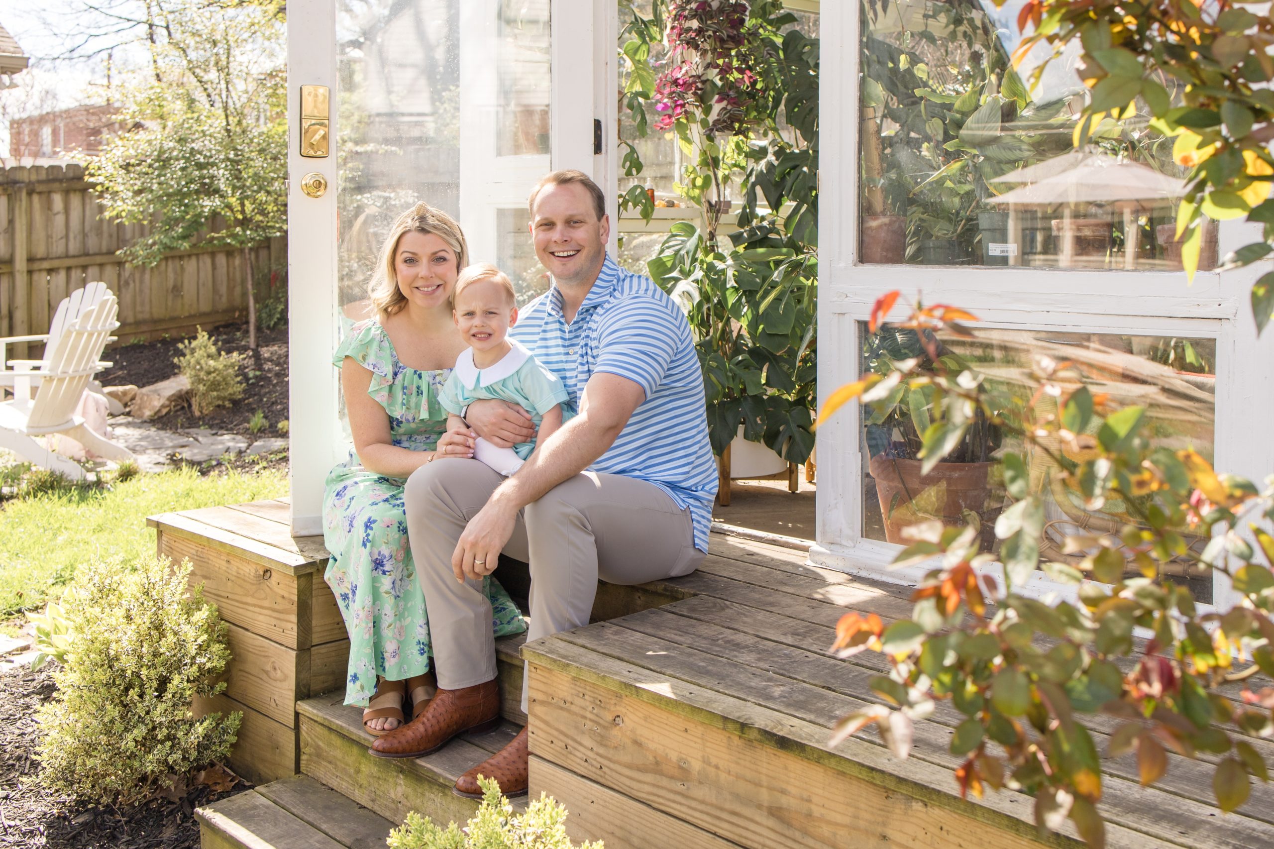 Family of 3 poses on steps of East Nash Greenhouse in Nashville, TN during spring mini session with team of family photographers, Wisp + Willow Photography Co. Click to see more from these mini sessions live on the blog now! 