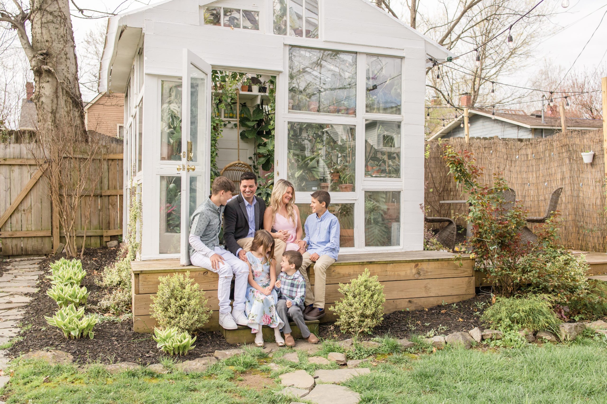 Family sits on steps of East Nash Greenhouse together during spring mini sessions in Nashville, TN. Click to see more from this set of minis by Wisp + Willow Photography Co. live on the blog now!