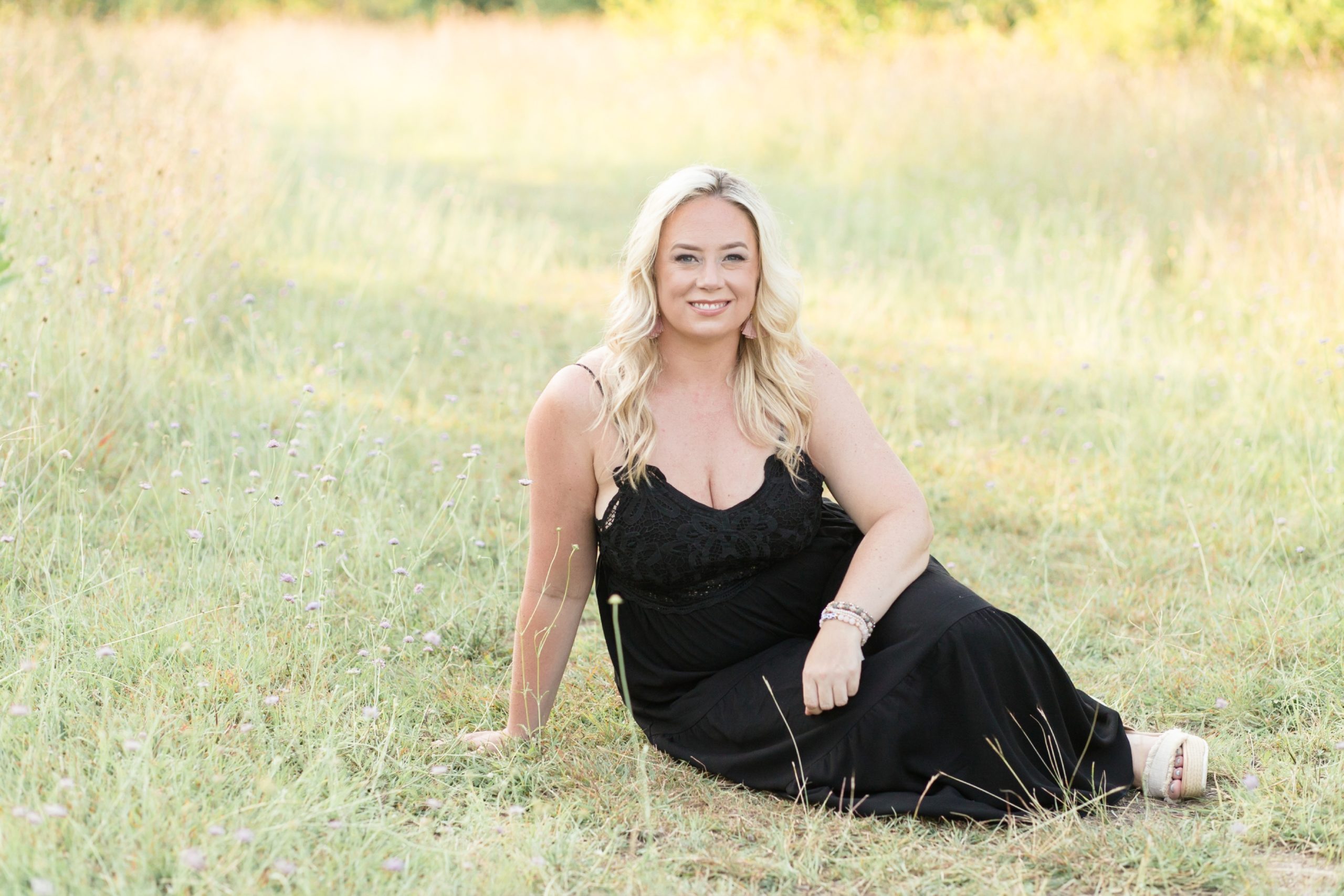 Mom sits in grassy field for portrait with family photography team Wisp + Willow Photography Co. Click to see more from this sweet session live on the blog now! 