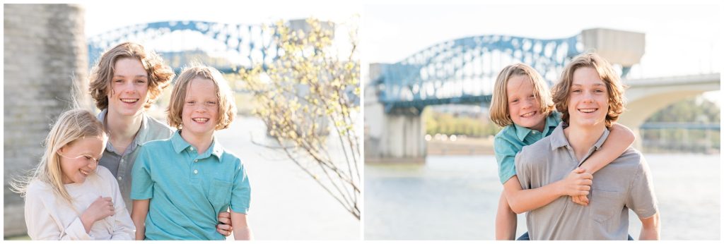 The kids are seen here hugging with the bridge and lake just in background. The daughter is wearing a light cream-colored long-sleeved shirt,  The first son is dressed in a grey polo shirt. The second son is wearing a green polo shirt. Coolidge Park Family Session | Chattanooga, TN