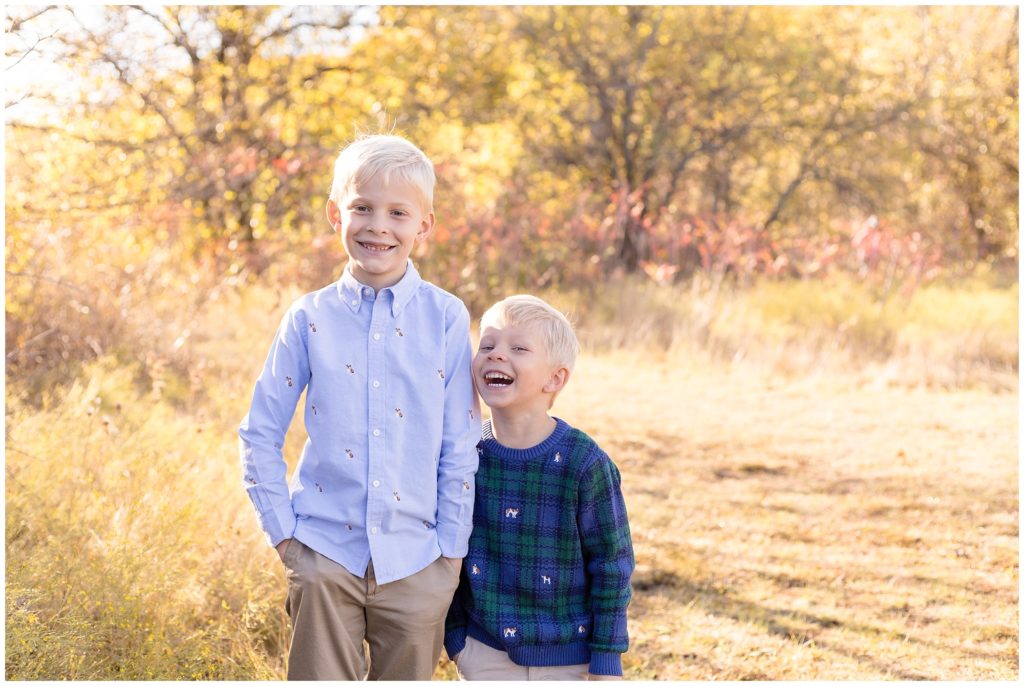 Brothers are standing in an open field with fall leaves in the background. 1st brother is wearing a light blue long sleeve button-up shirt with khaki pants. 2nd brother is wearing a blue and green checkered long sleeve sweater and khaki pants.
Frisco Commons | Frisco, TX