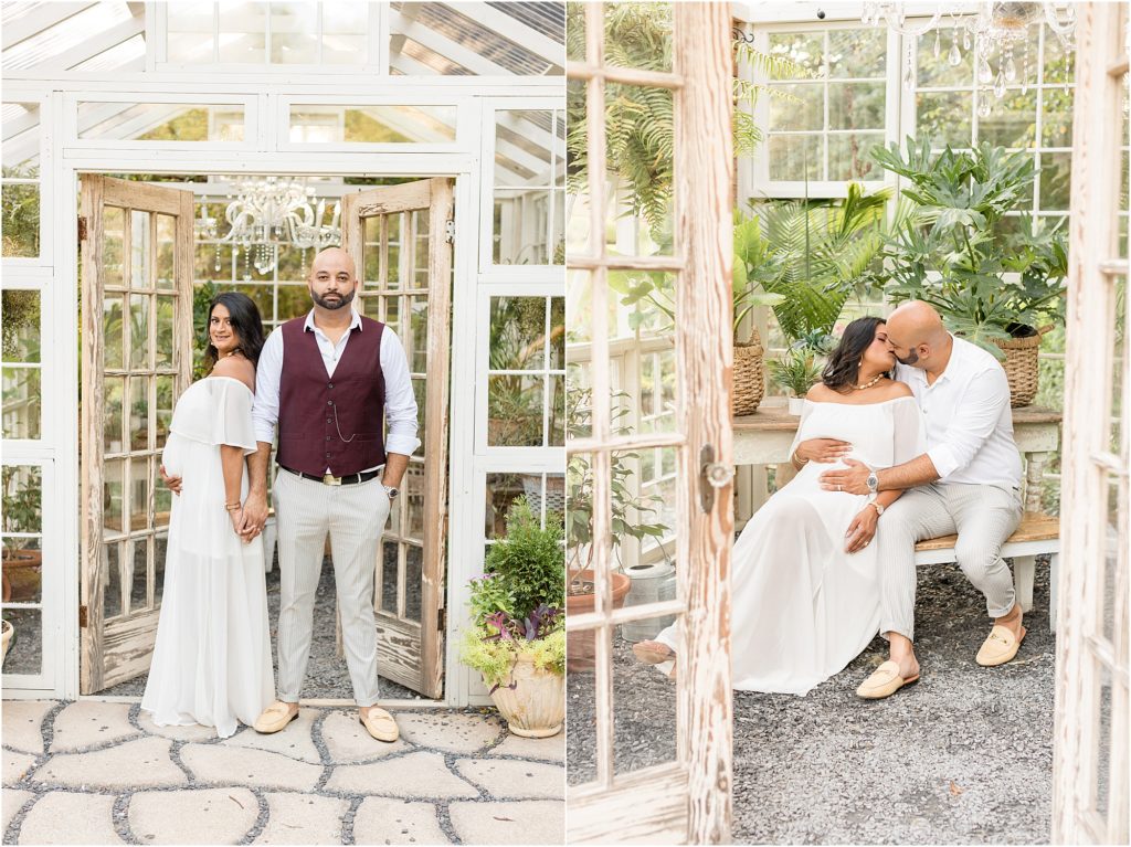 Parents-to-be are pictured here in the cutest little greenhouse. Mom-to-be is wearing a long off-the-shoulder white dress. Dad-to-be is wearing khaki pants and a white button-up shirt and a burgundy vest.