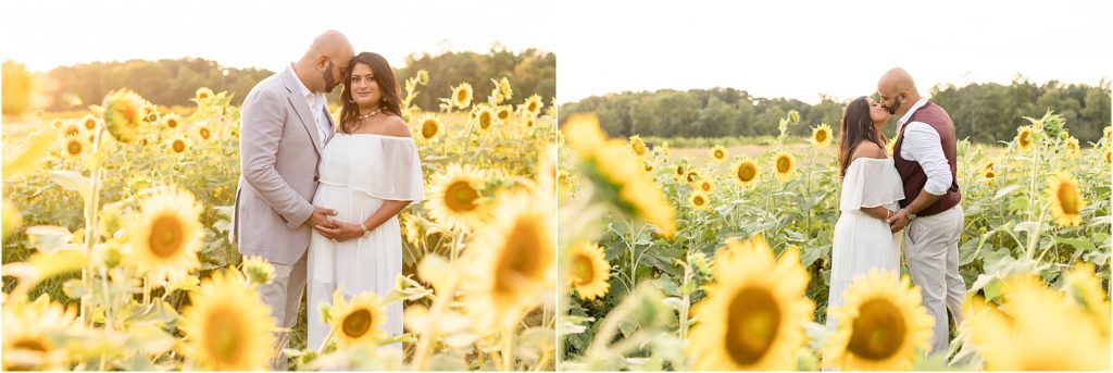 Beautiful parents-to-be are standing in a field of sunflowers. Mom-to-be is wearing a long off-the-shoulder white dress. Dad-to-be is wearing a grey suit and white button-up shirt. He is also wearing a burgundy vest.