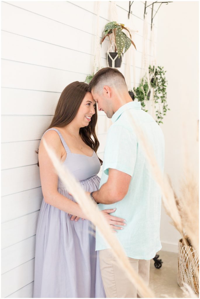 Expecting couple hold each other close during maternity shoot in McKinney, TX with Wisp + Willow Photography Team.
