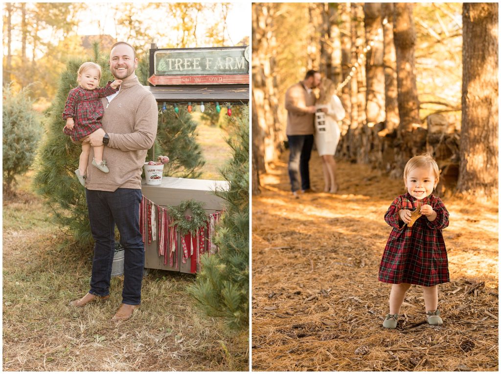 Dad in brown sweater holds daughter in red plaid dress in front of Tree Farm stand. Dad and mom kiss while holding baby announcement photos while toddler daughter stands in front and smiles while holding a leaf. 