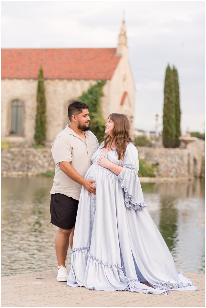 Husband and wife touch wife's pregnant belly and looks into each other's eyes during maternity session in McKinney, TX.