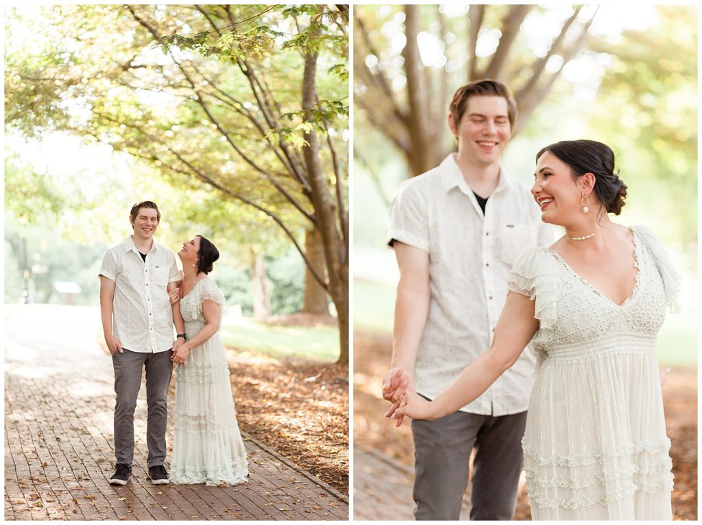 beautiful couple wearing white smile and dance together as new parents in historic oak view park in raleigh north carolina.  click to see their new family session on the blog.